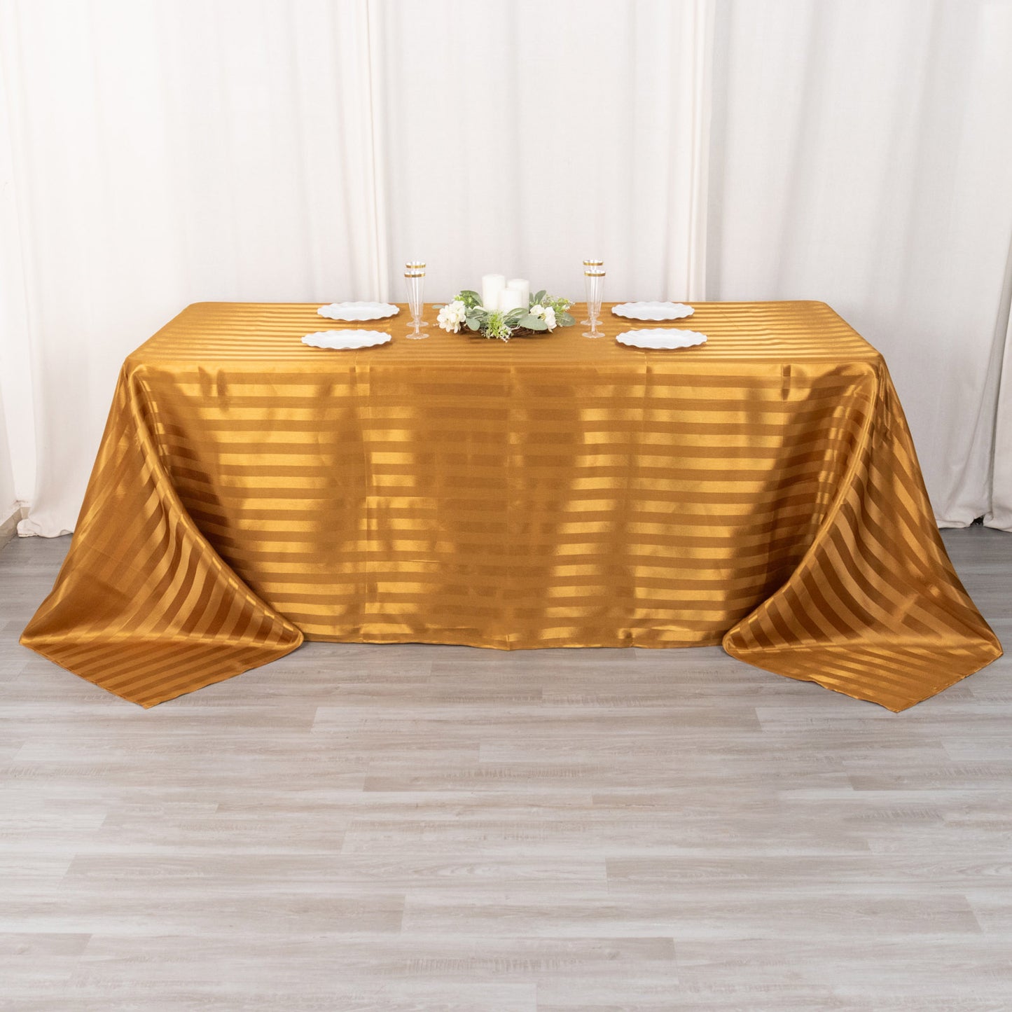 Gold satin stripe rectangular tablecloth on a table.