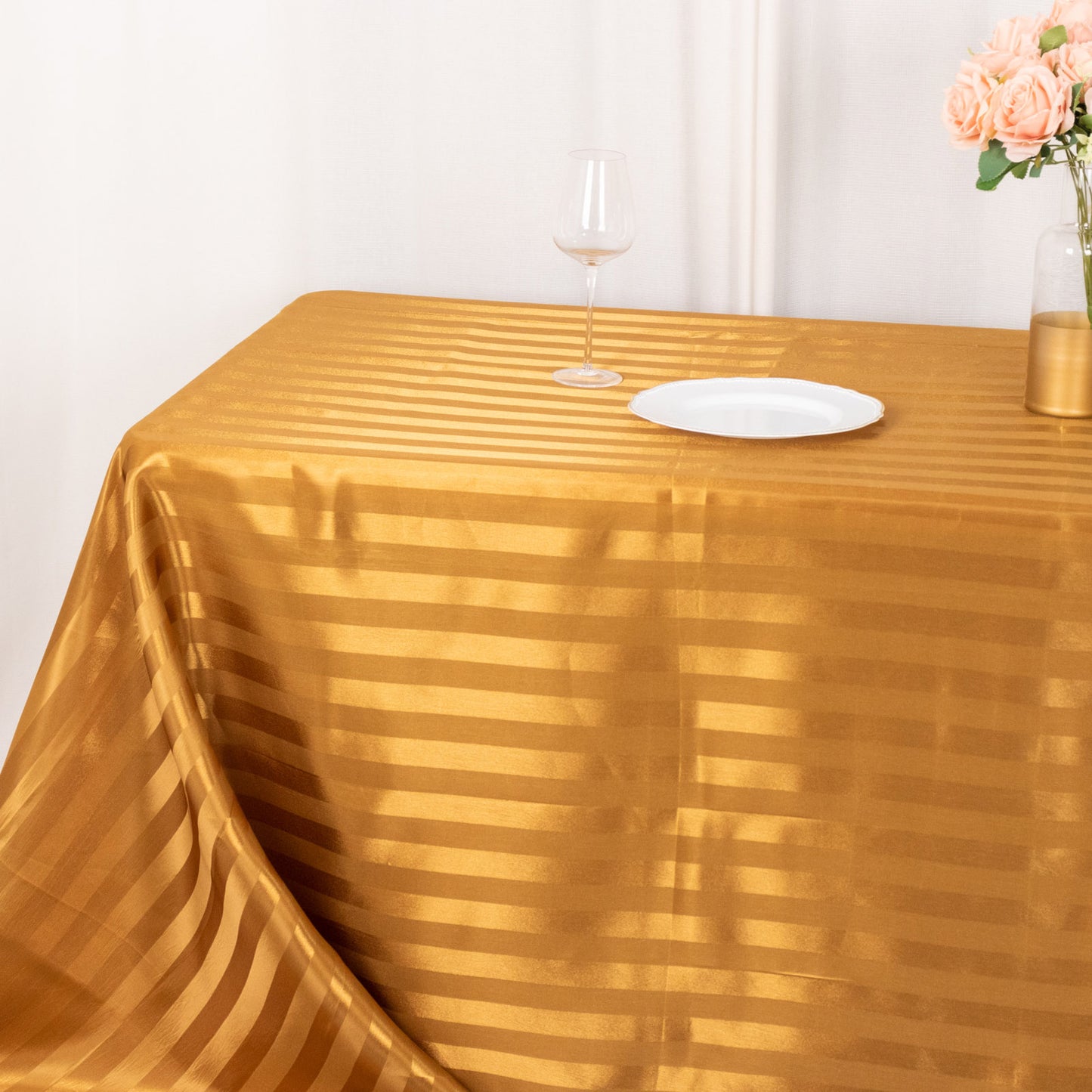 Gold satin stripe tablecloth on a rectangular table setting.