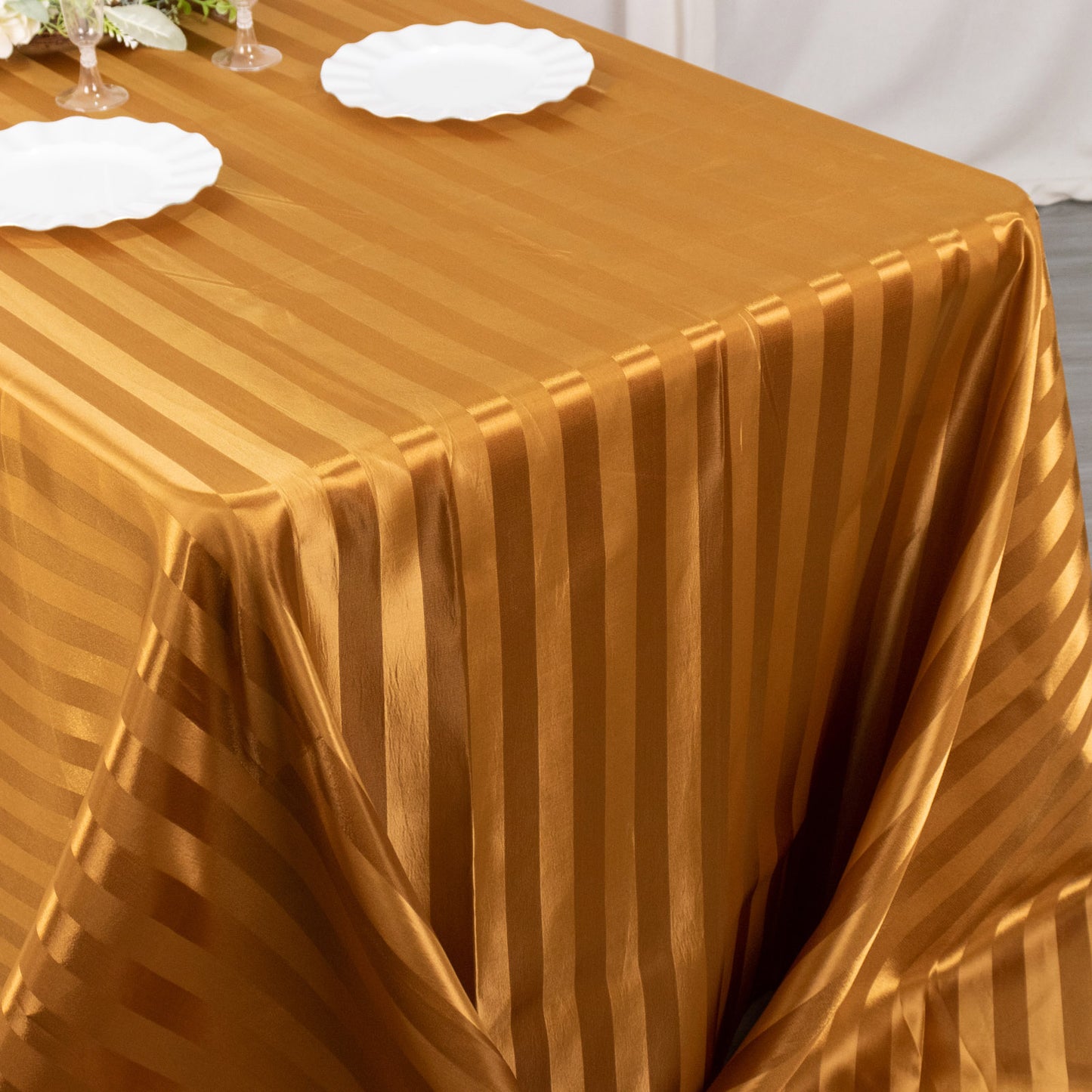 Gold satin stripe tablecloth on a rectangular table.