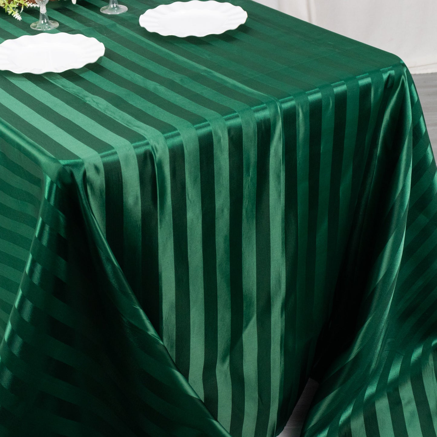 Hunter emerald green satin stripe tablecloth on a dining table.