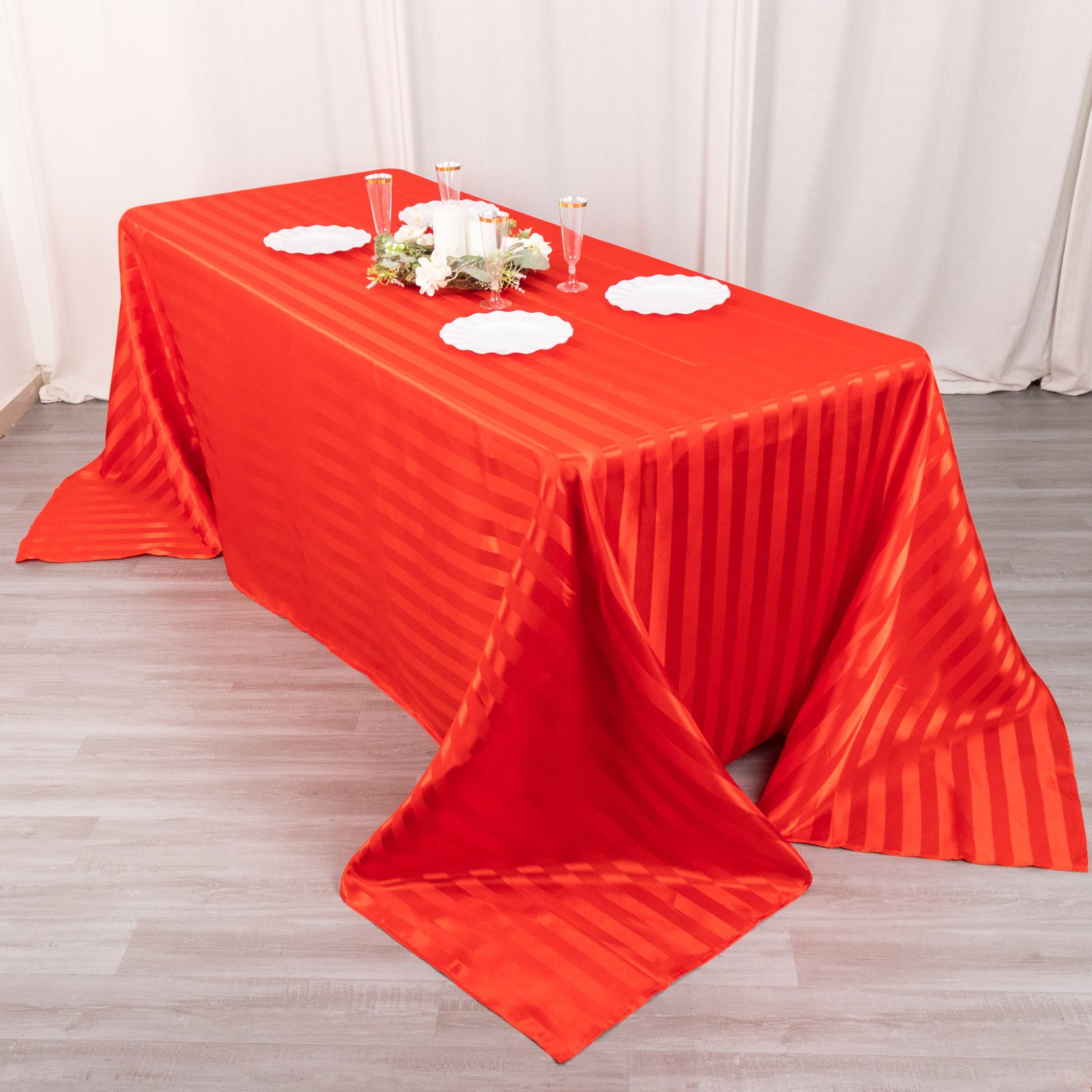 Red satin stripe tablecloth on a rectangular table.