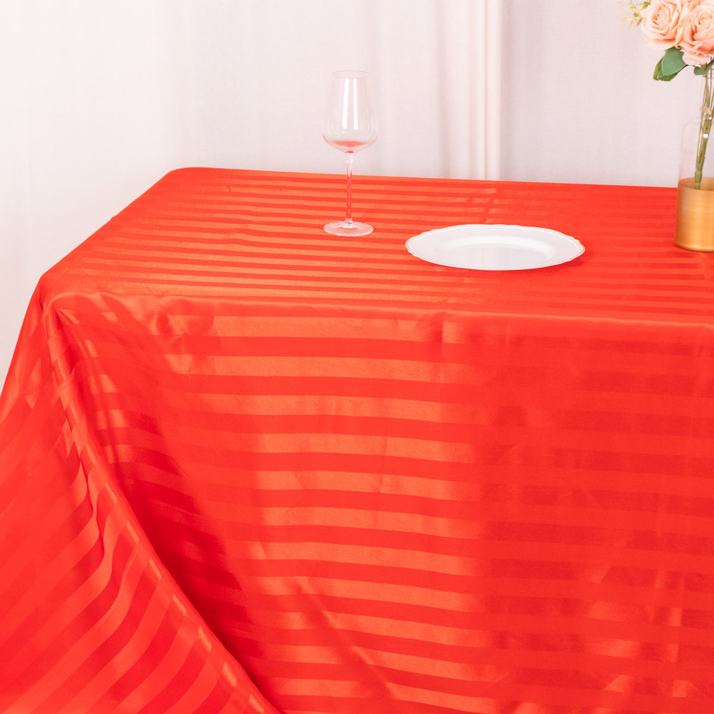 Red satin stripe seamless rectangular tablecloth on a table.