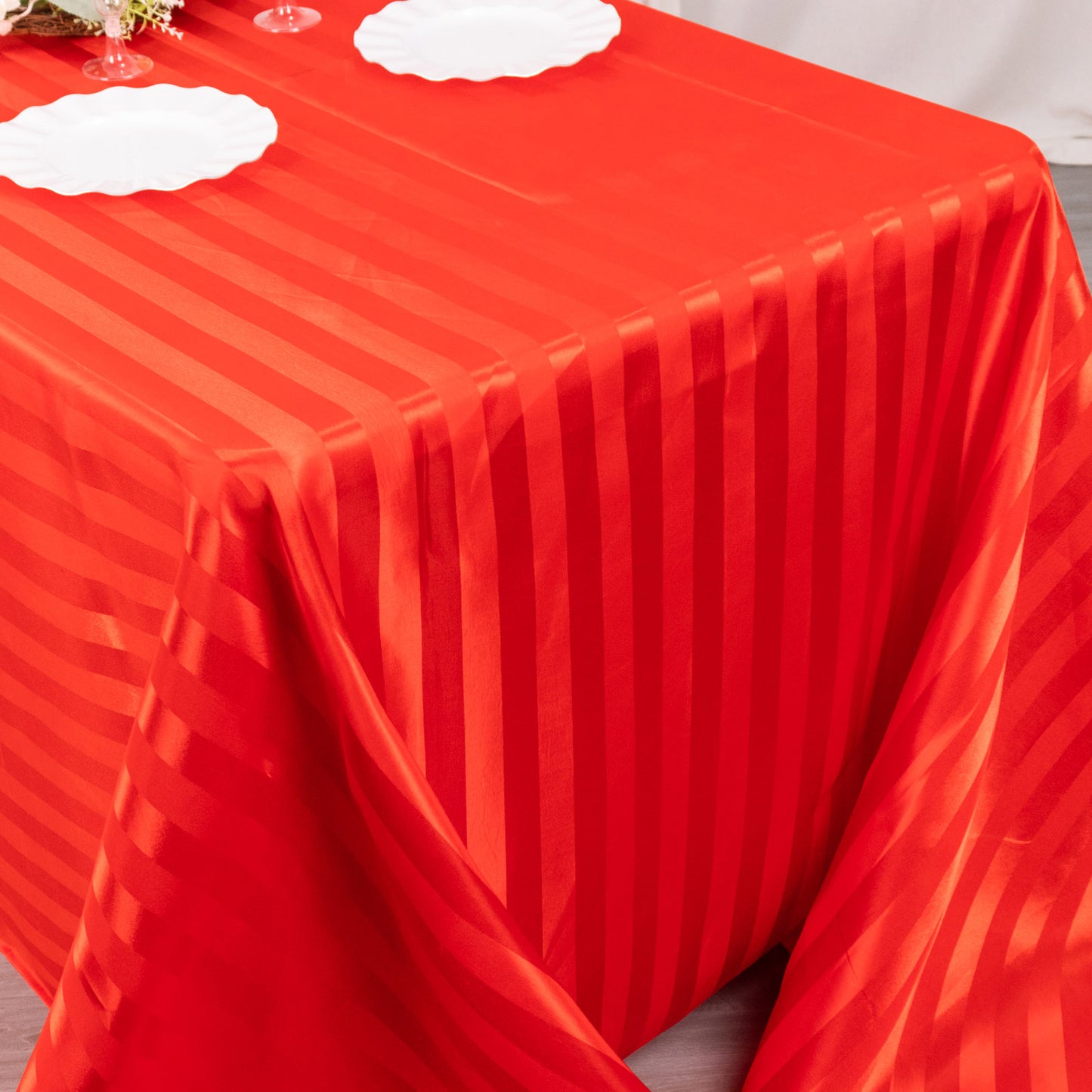 Red satin stripe tablecloth on a rectangular table.