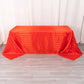 Red satin stripe rectangular tablecloth on a wooden surface.