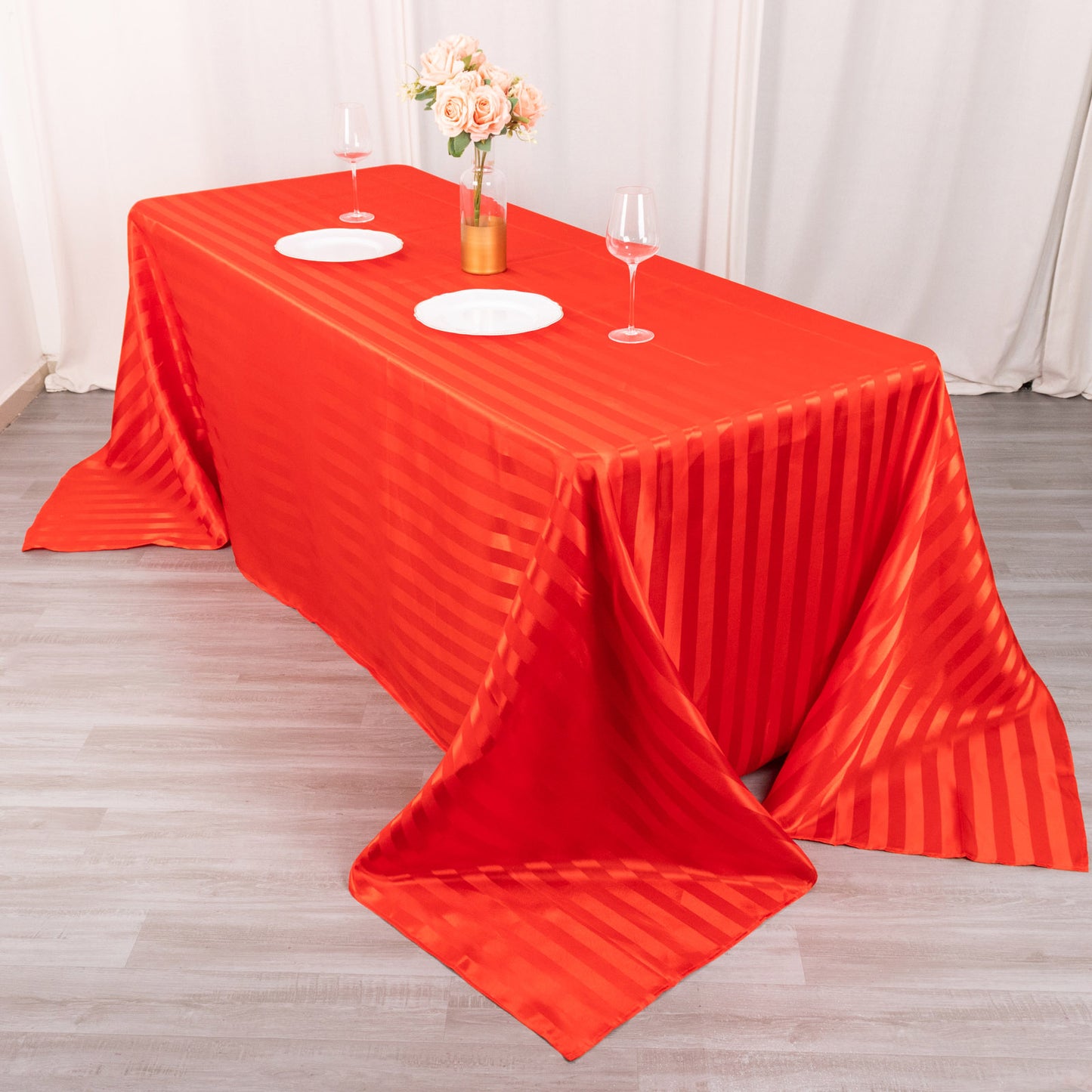 Red satin stripe seamless rectangular tablecloth on a dining table.