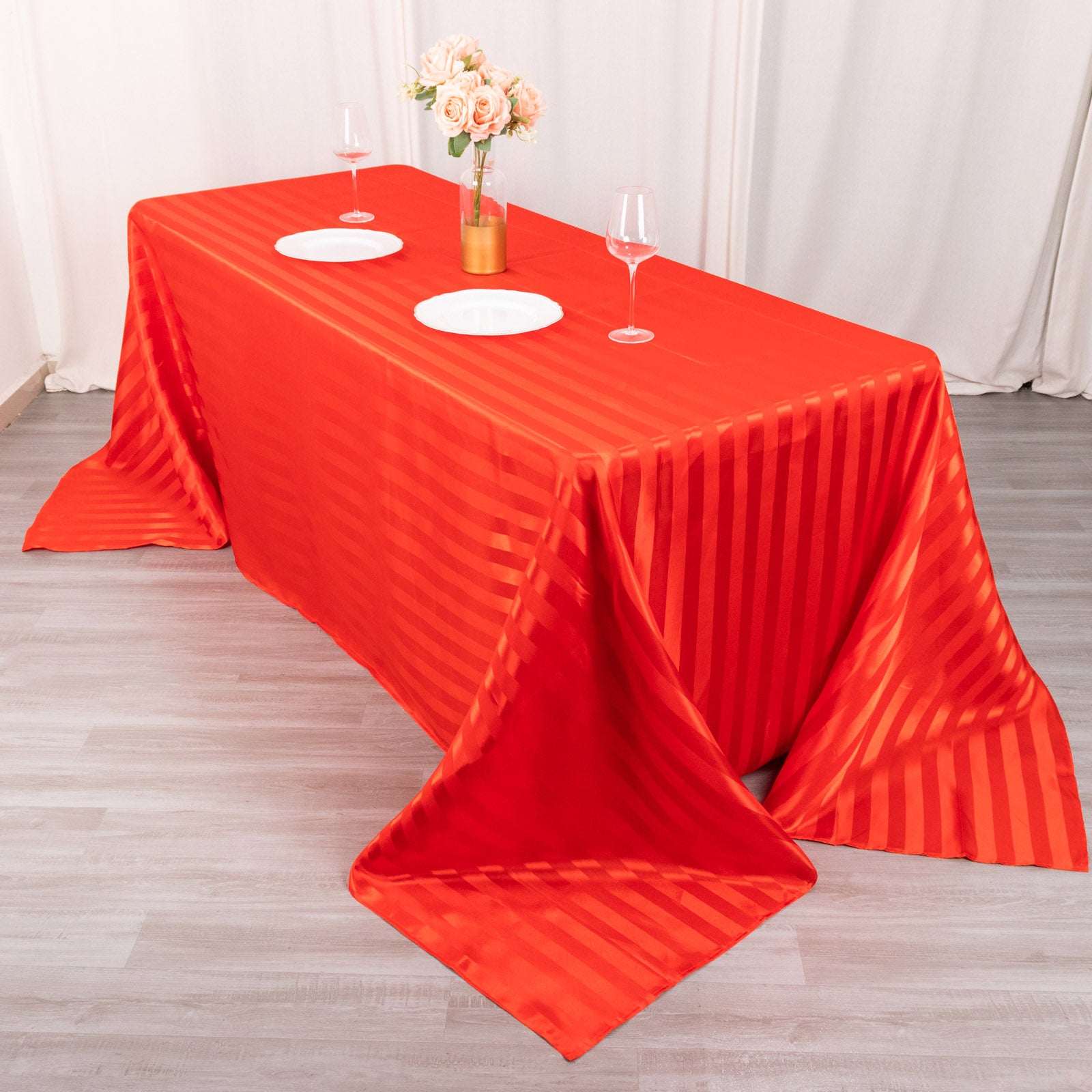 Red satin stripe seamless rectangular tablecloth on a dining table.