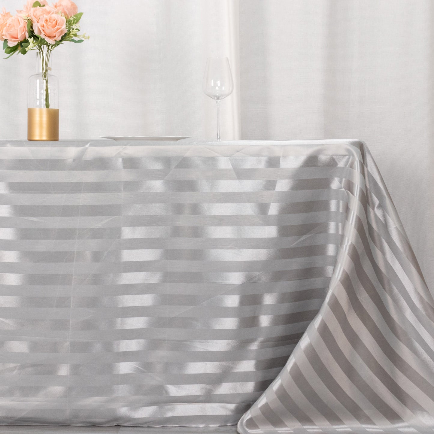 Silver satin stripe seamless rectangular tablecloth on a table.