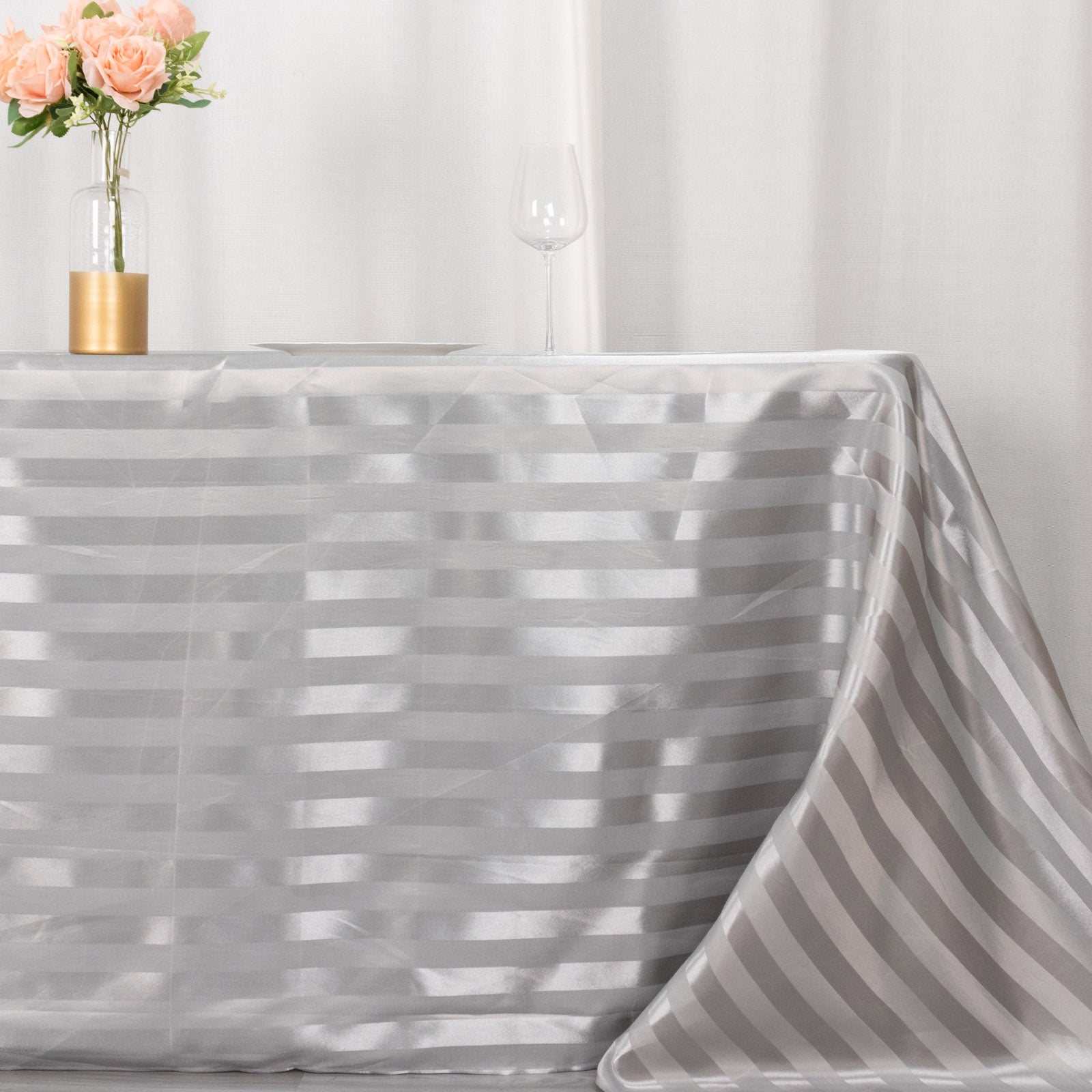 Silver satin stripe seamless rectangular tablecloth on a table.