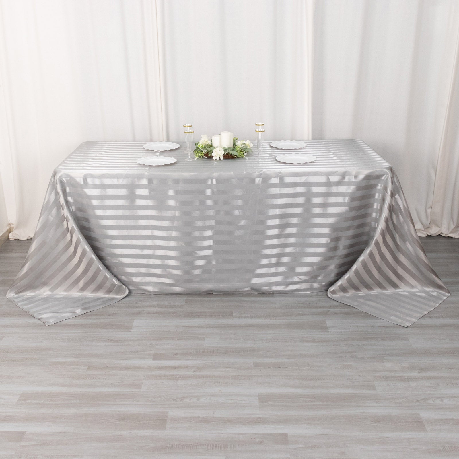 Silver satin stripe rectangular tablecloth on a dining table.