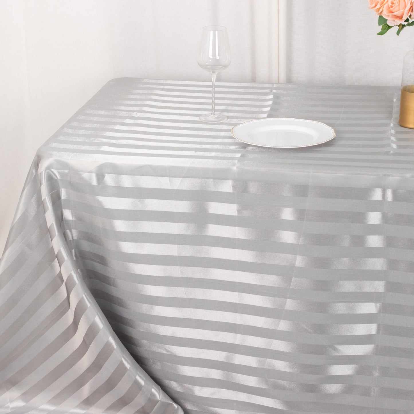 Silver satin stripe rectangular tablecloth on a dining table.