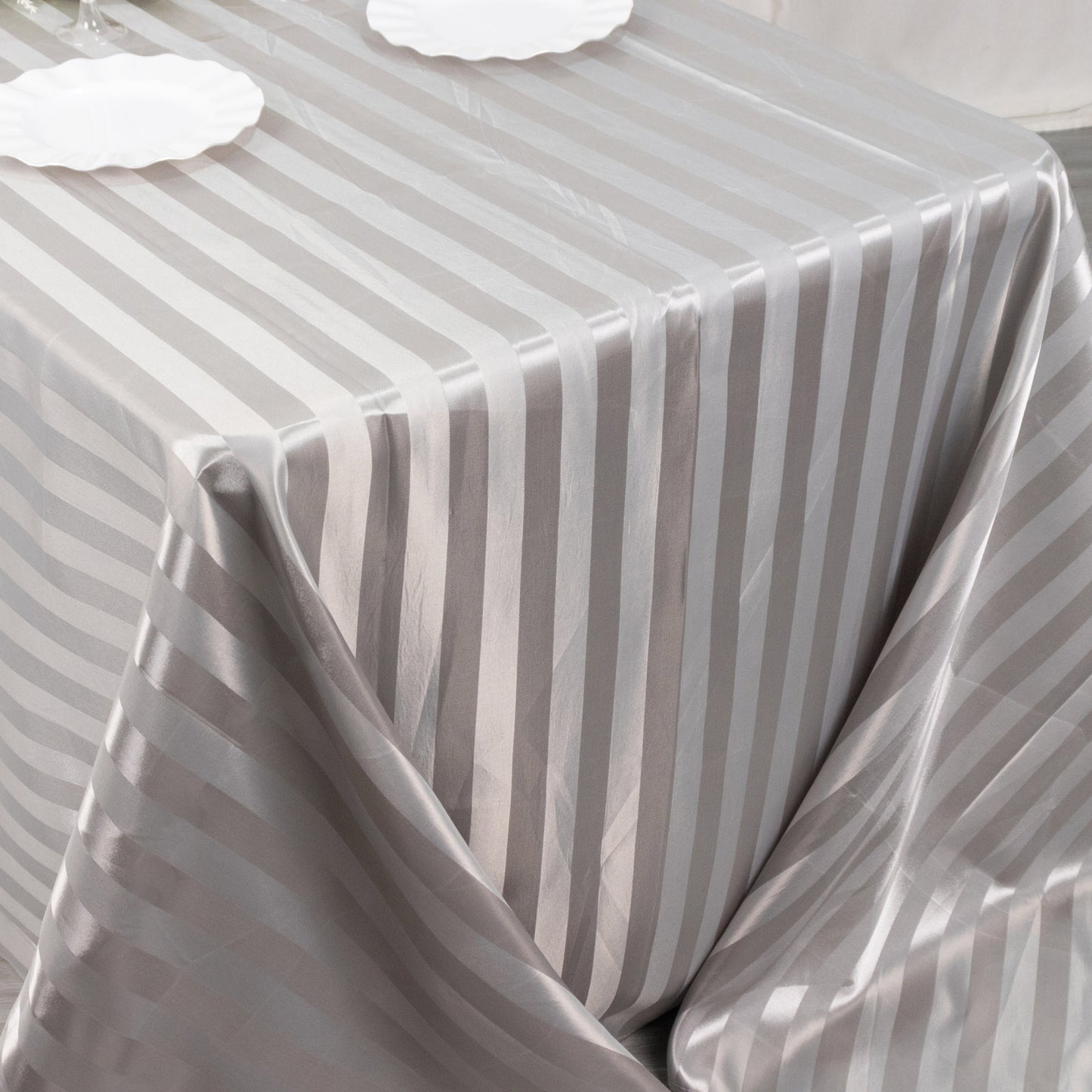 Silver satin stripe tablecloth on a rectangular table.