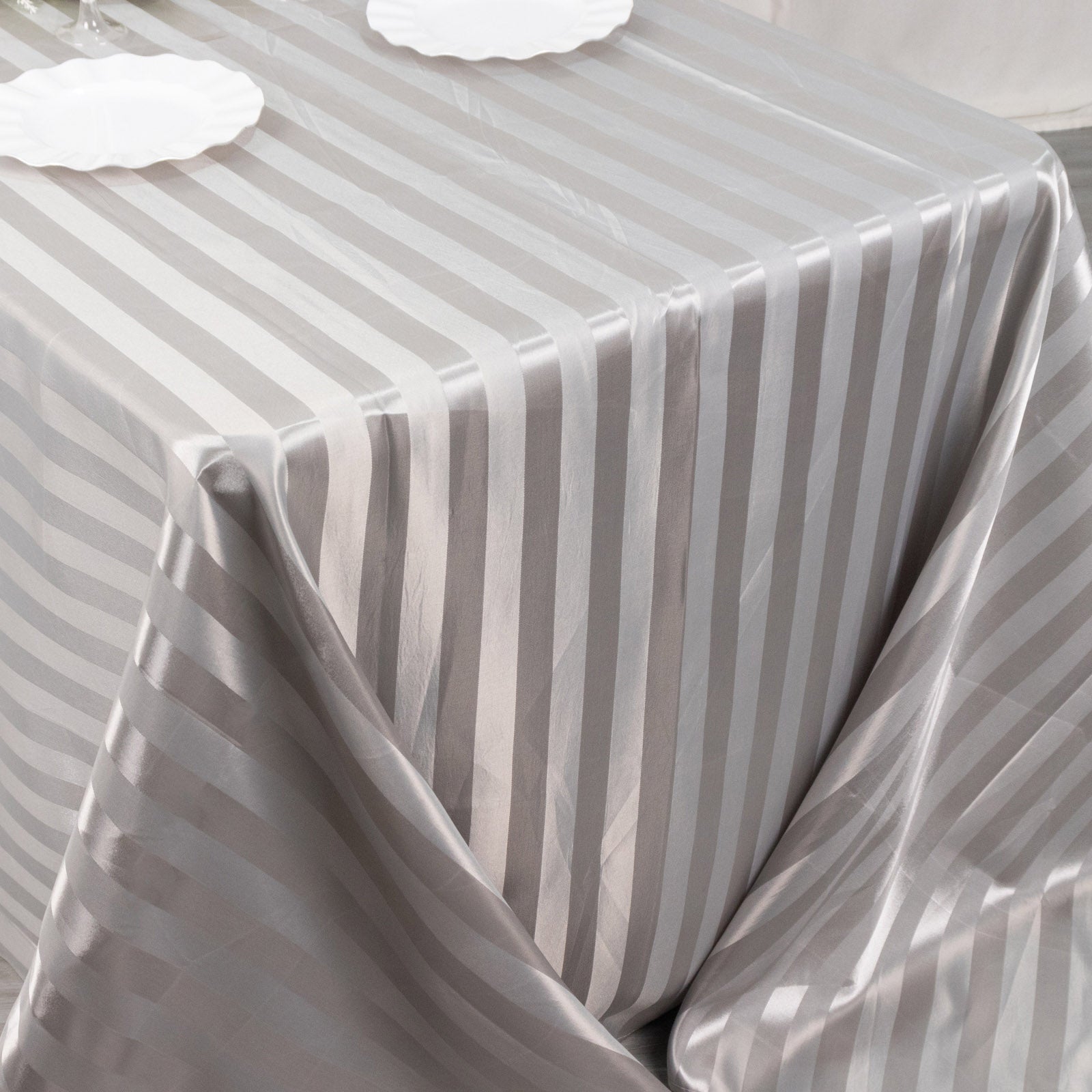 Silver satin stripe tablecloth on a rectangular table.