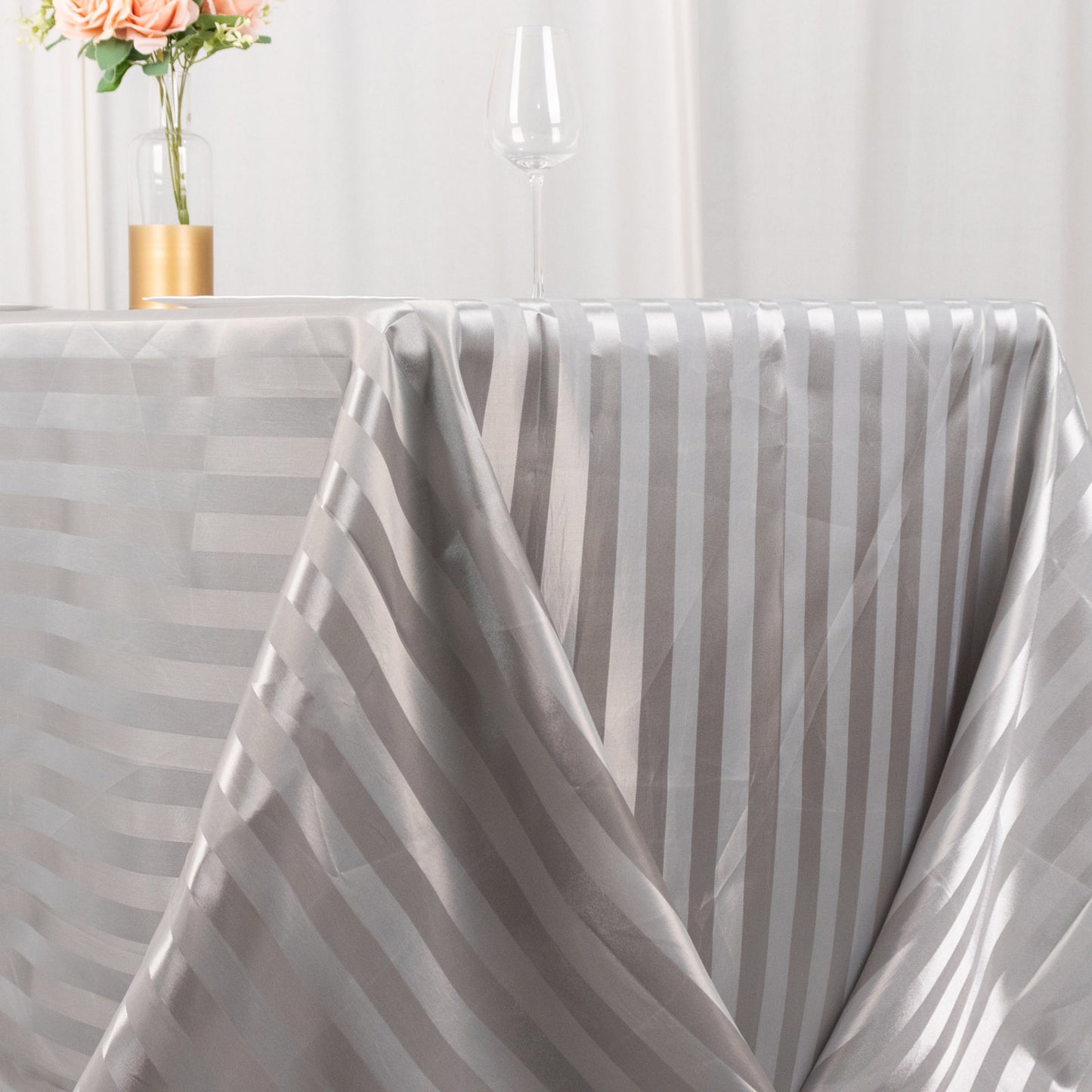 Silver satin stripe rectangular tablecloth on a dining table.