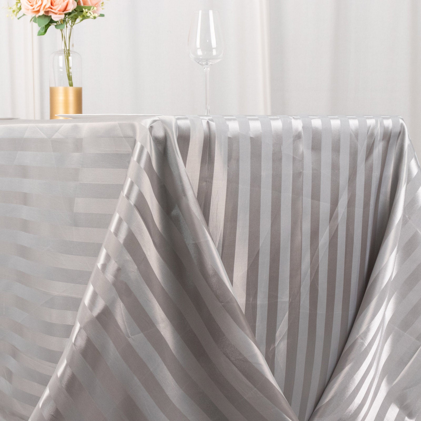 Silver satin stripe rectangular tablecloth on a dining table.
