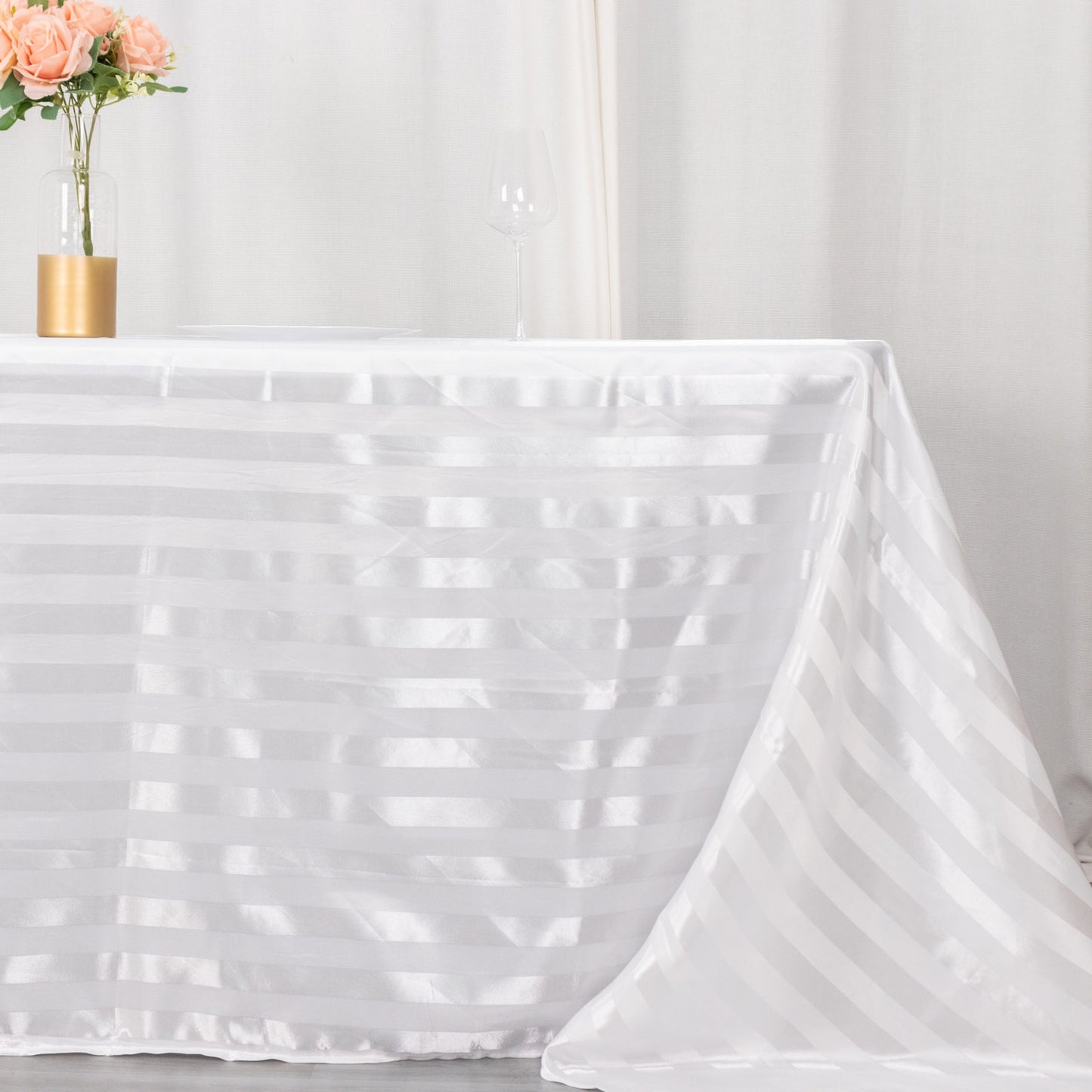 White satin stripe tablecloth on a rectangular table.