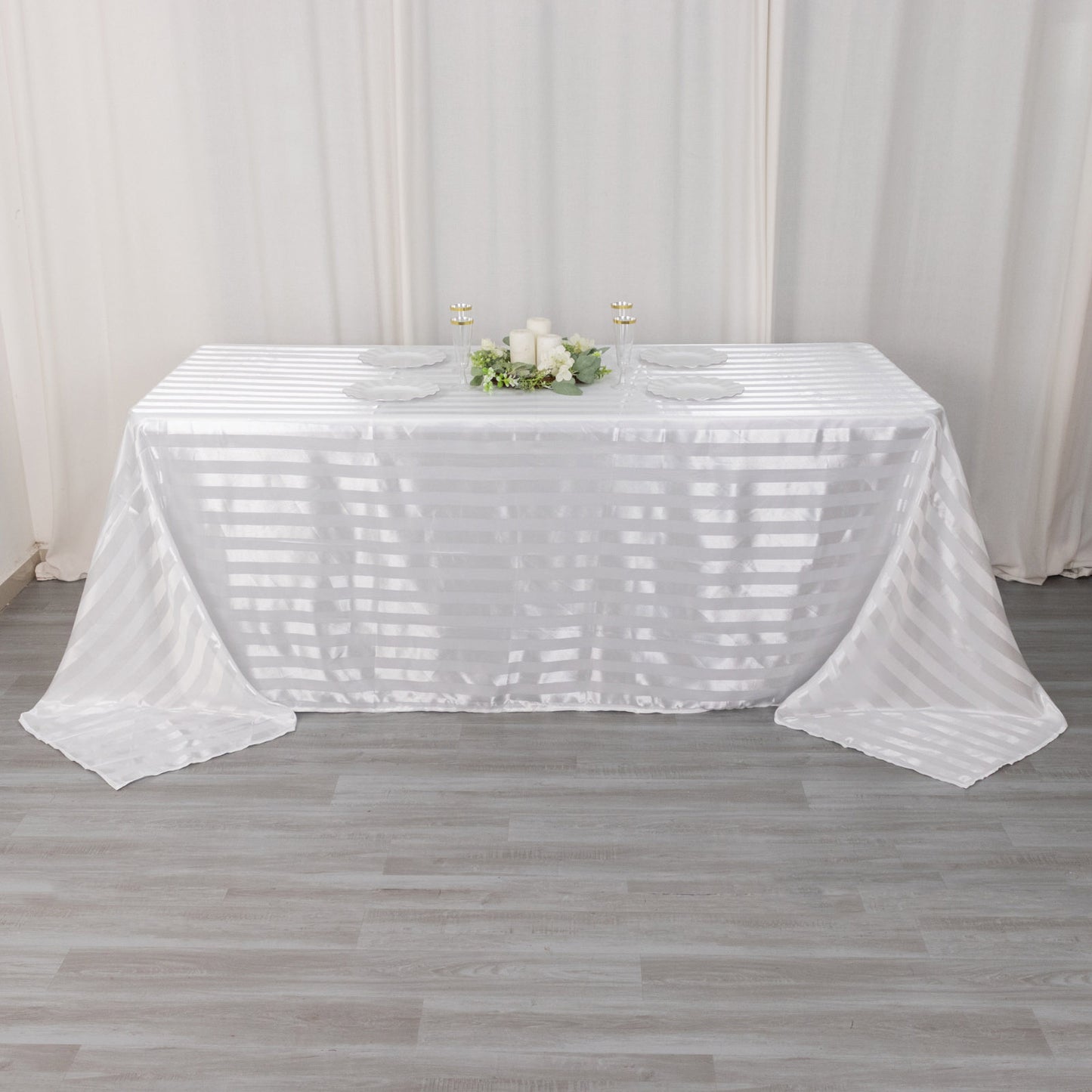 White satin stripe tablecloth on a rectangular table.