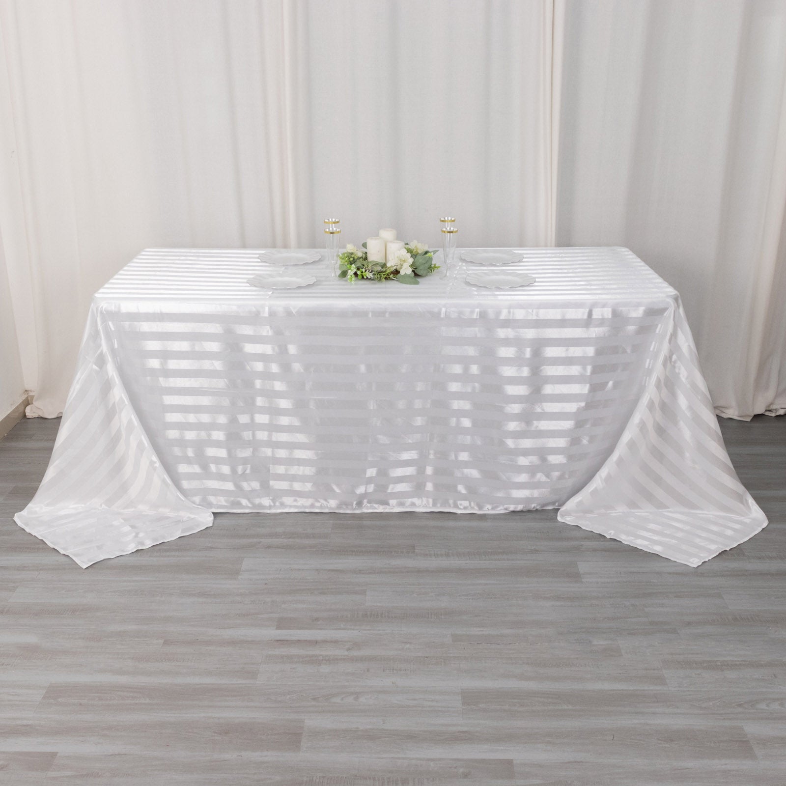 White satin stripe tablecloth on a rectangular table.