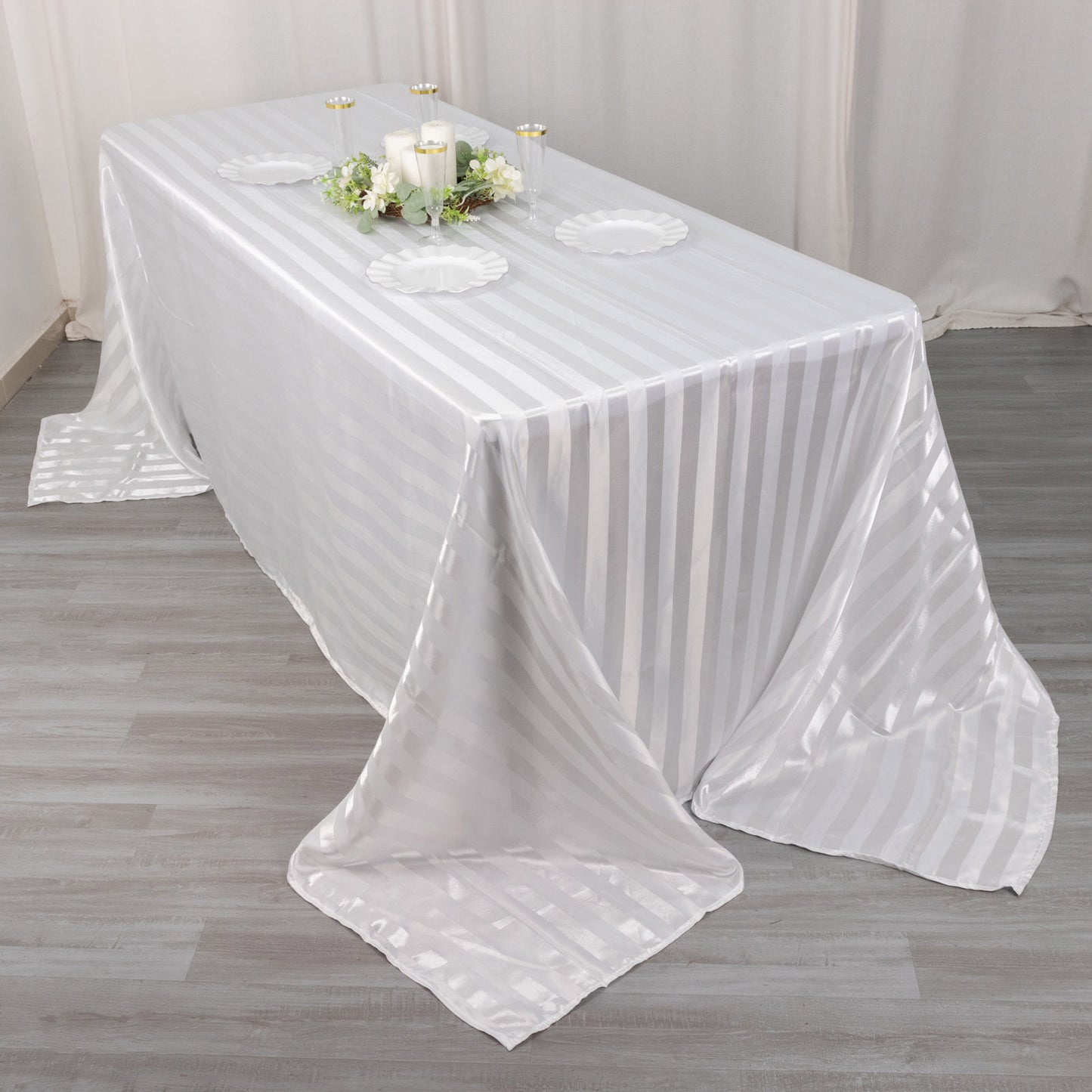 White satin stripe tablecloth on a rectangular table.