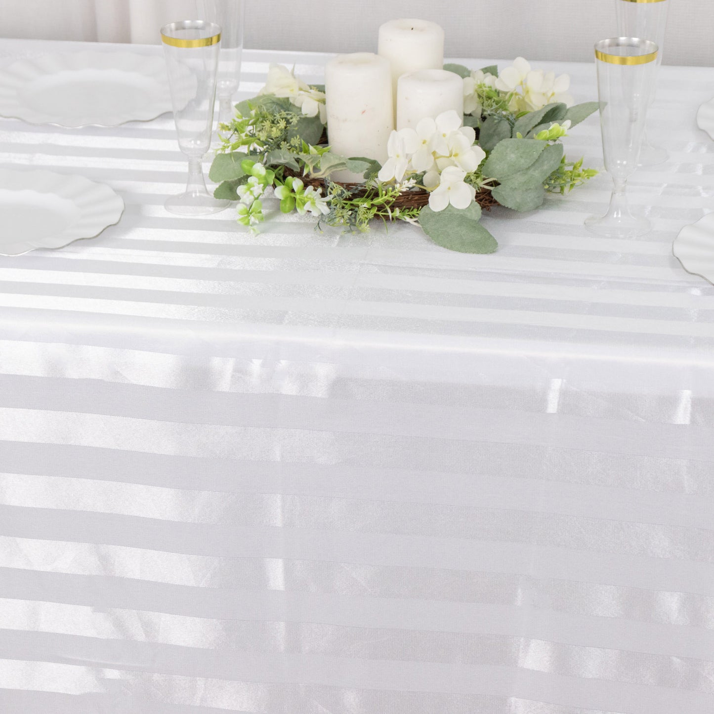 White satin stripe rectangular tablecloth on a decorated table.