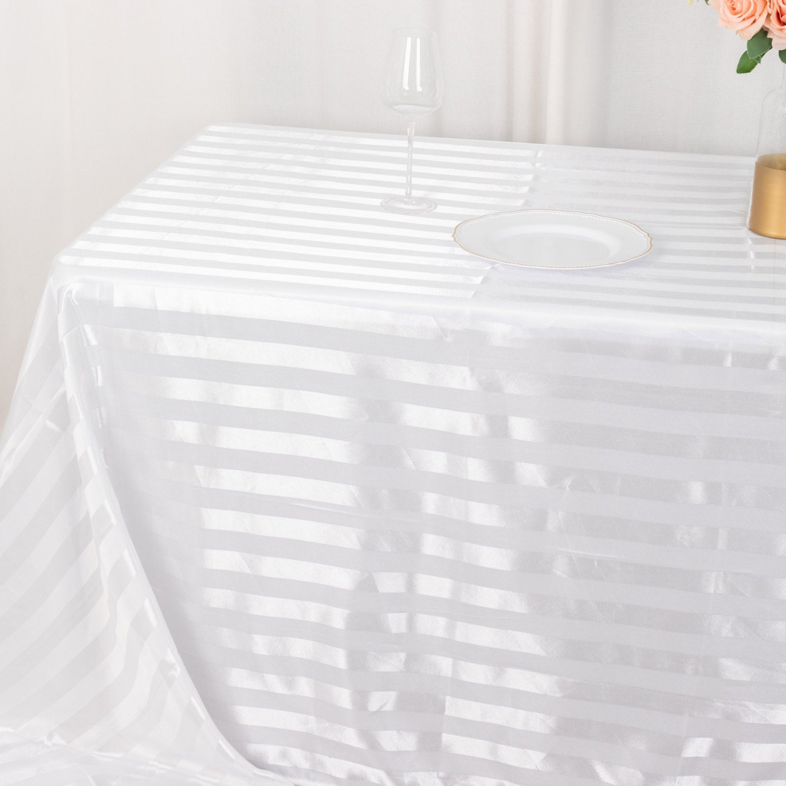 White satin stripe rectangular tablecloth on a table.