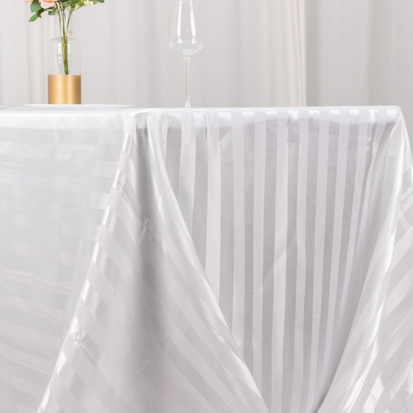 White satin stripe rectangular tablecloth on a dining table.