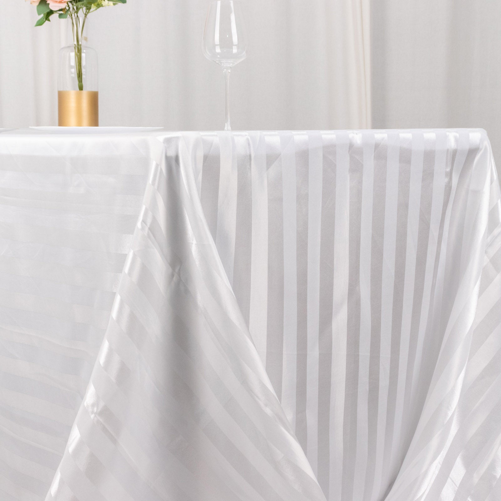White satin stripe rectangular tablecloth on a dining table.