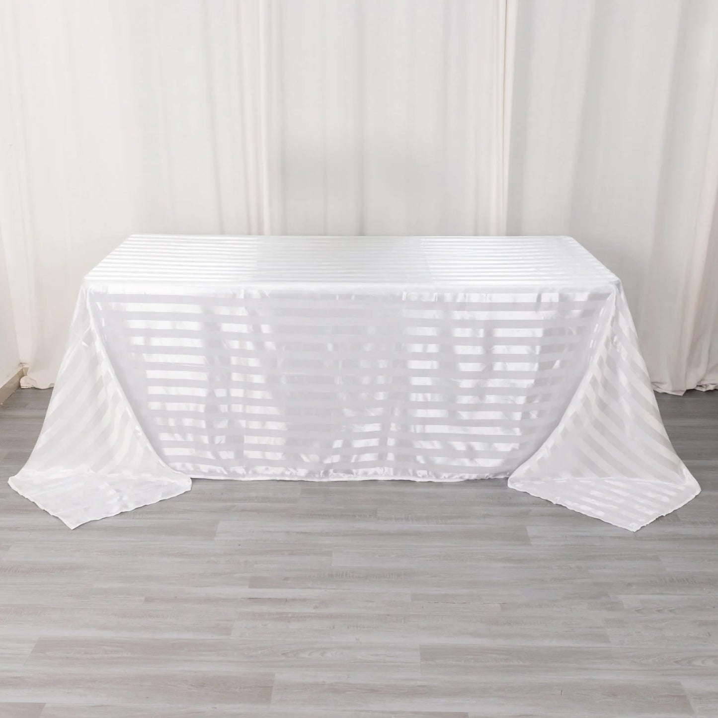 White satin stripe tablecloth on a rectangular table.