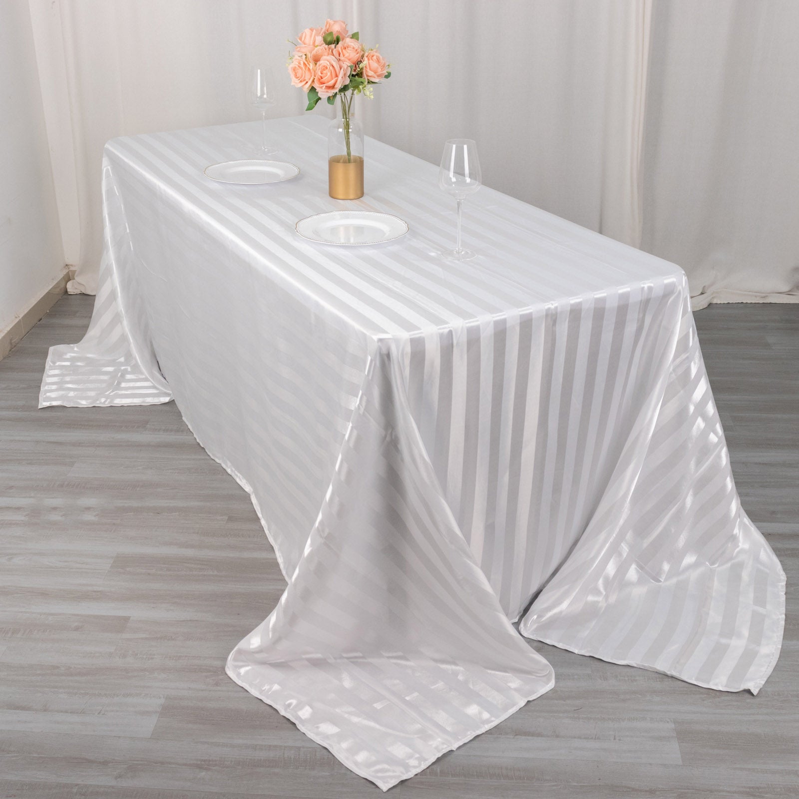 White satin stripe rectangular tablecloth on a dining table.