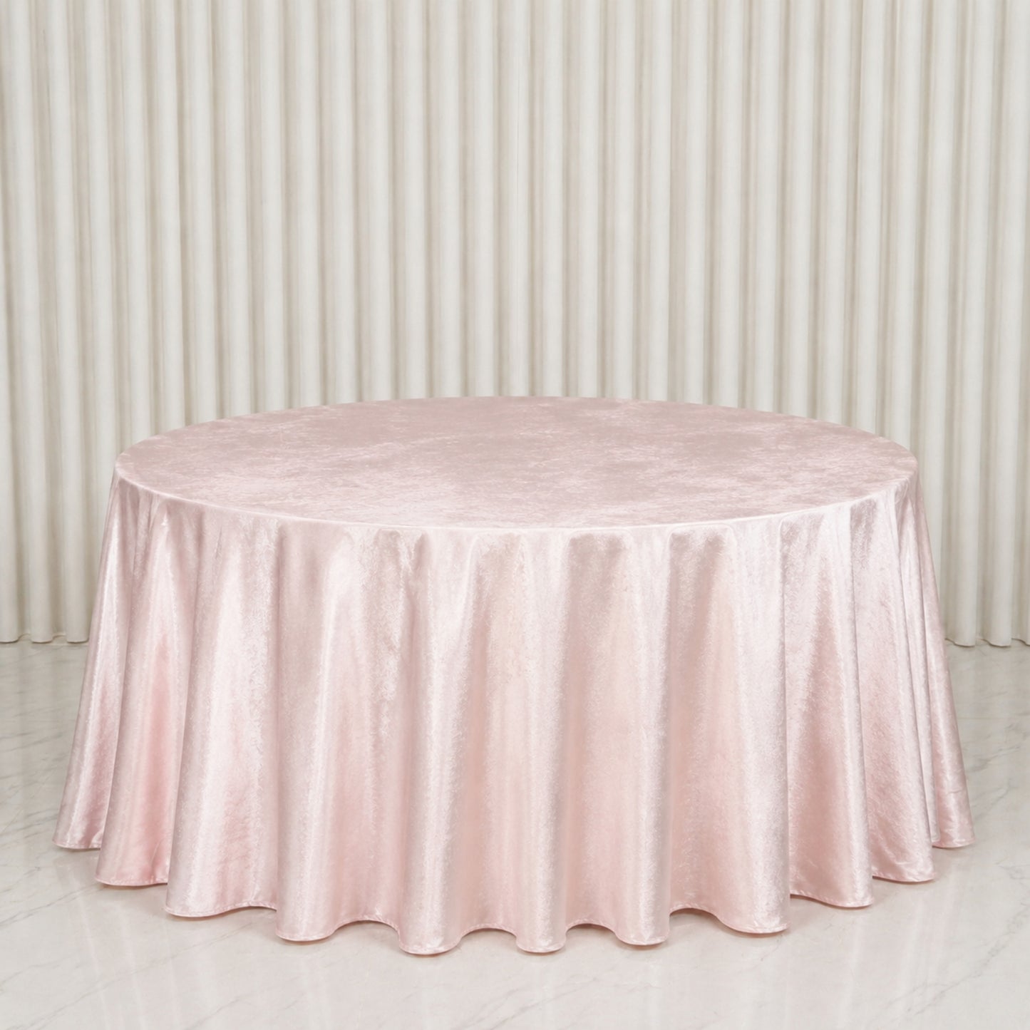 Blush round velvet tablecloth on a marble surface.