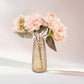 Amber gold crystal cut vase with pink flowers, ideal for table centerpieces.