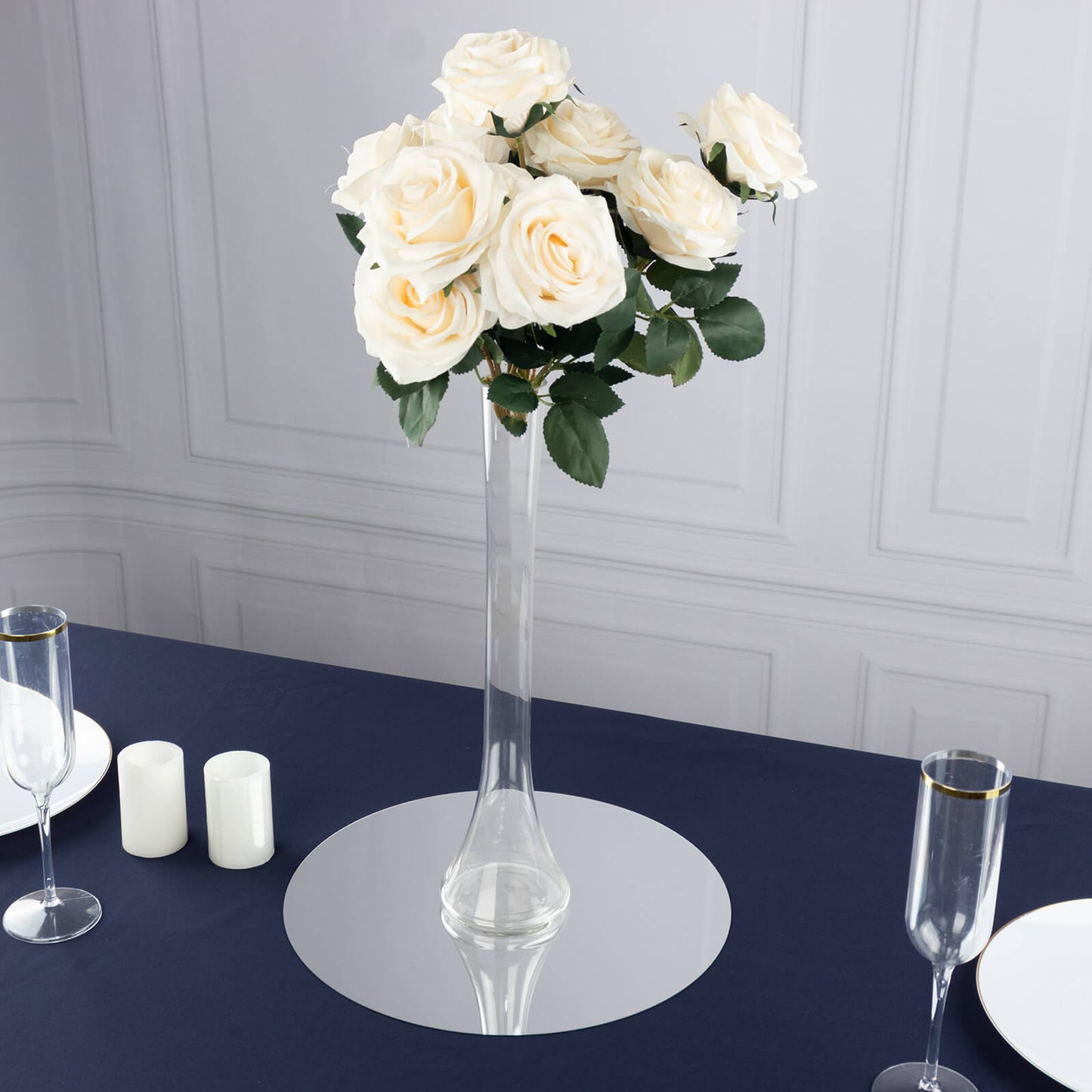 Clear glass Eiffel Tower vase with white roses, perfect for centerpieces.