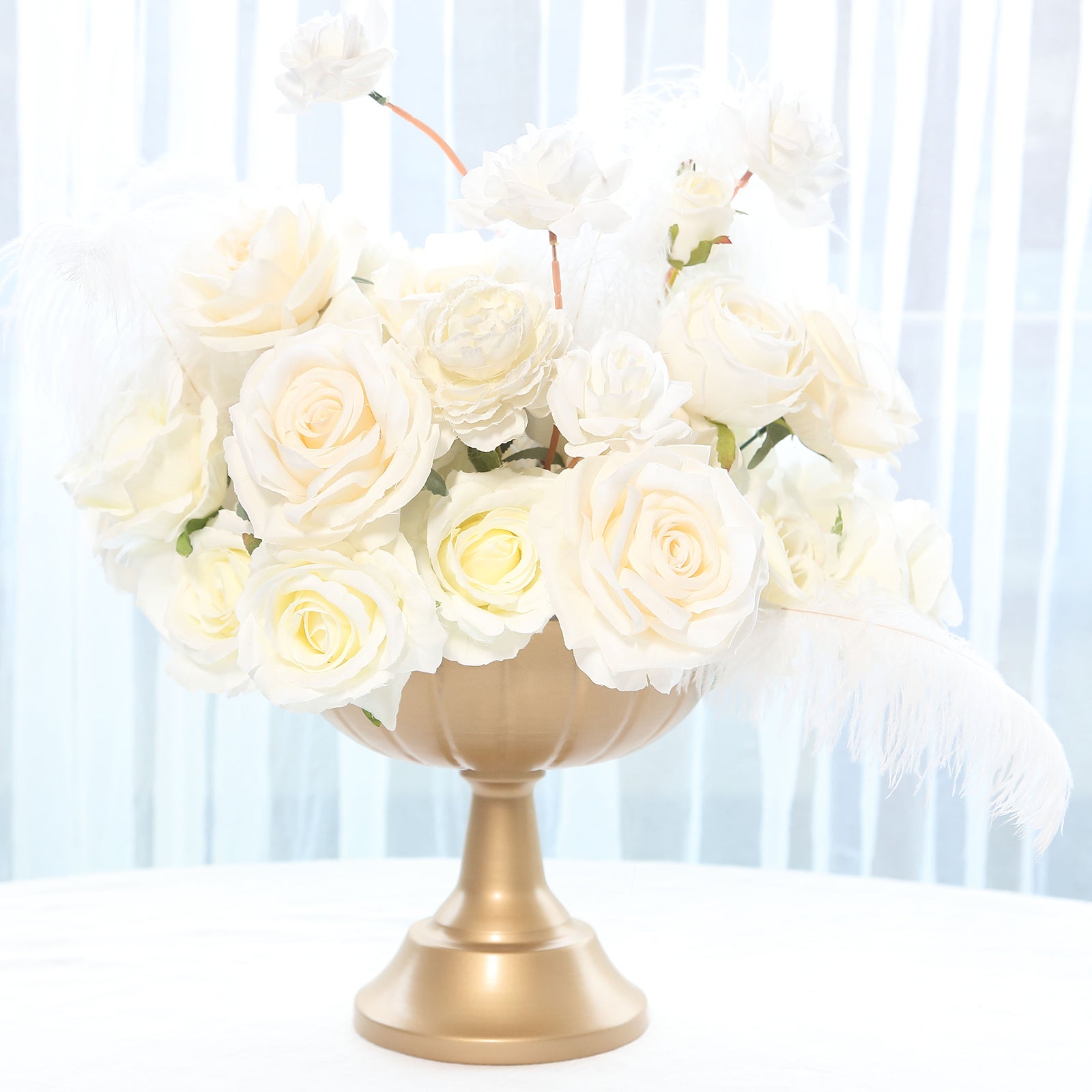 Gold metal compote pedestal bowl vase with white flowers.