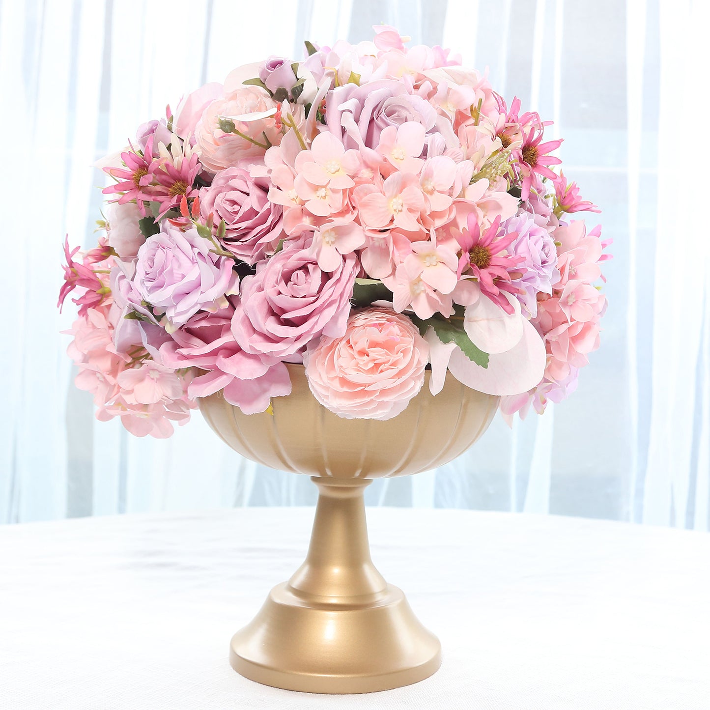Gold compote pedestal bowl vase with pink floral arrangement.