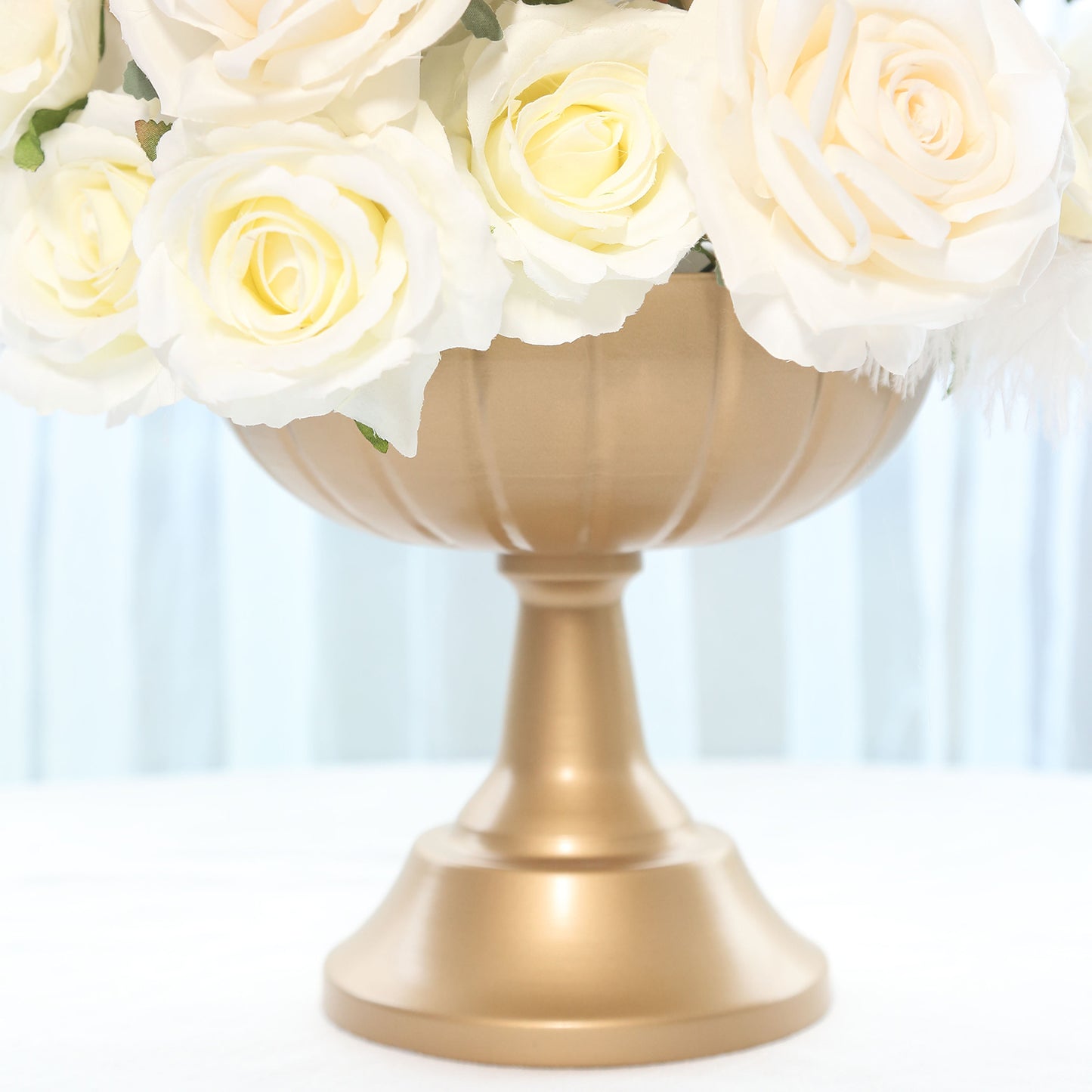 Gold metal compote pedestal bowl vase with white roses.