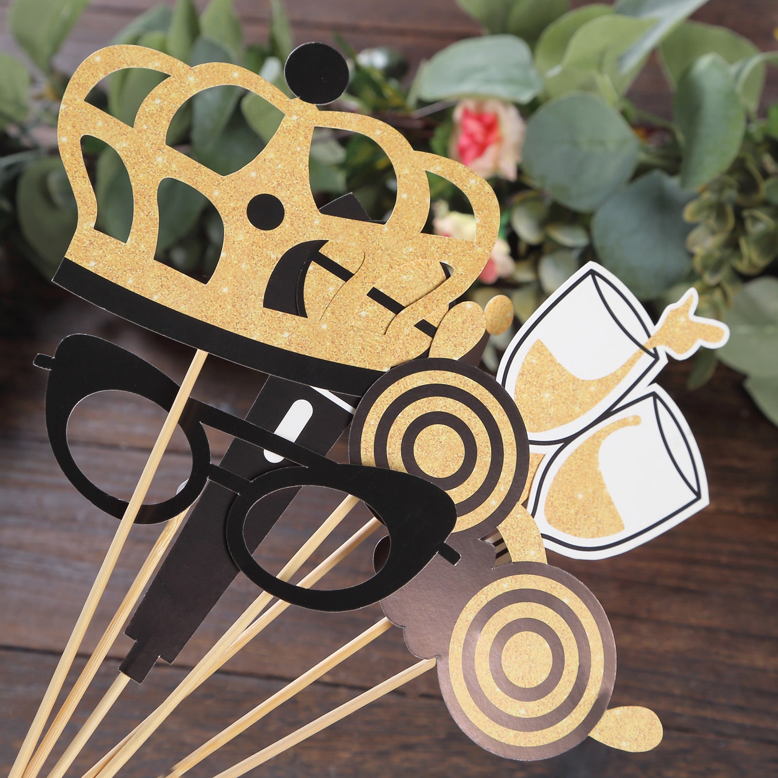 Vintage black and gold glitter party photo booth props on wooden background.