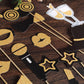 Vintage black and gold glitter party photo booth props on wooden surface.