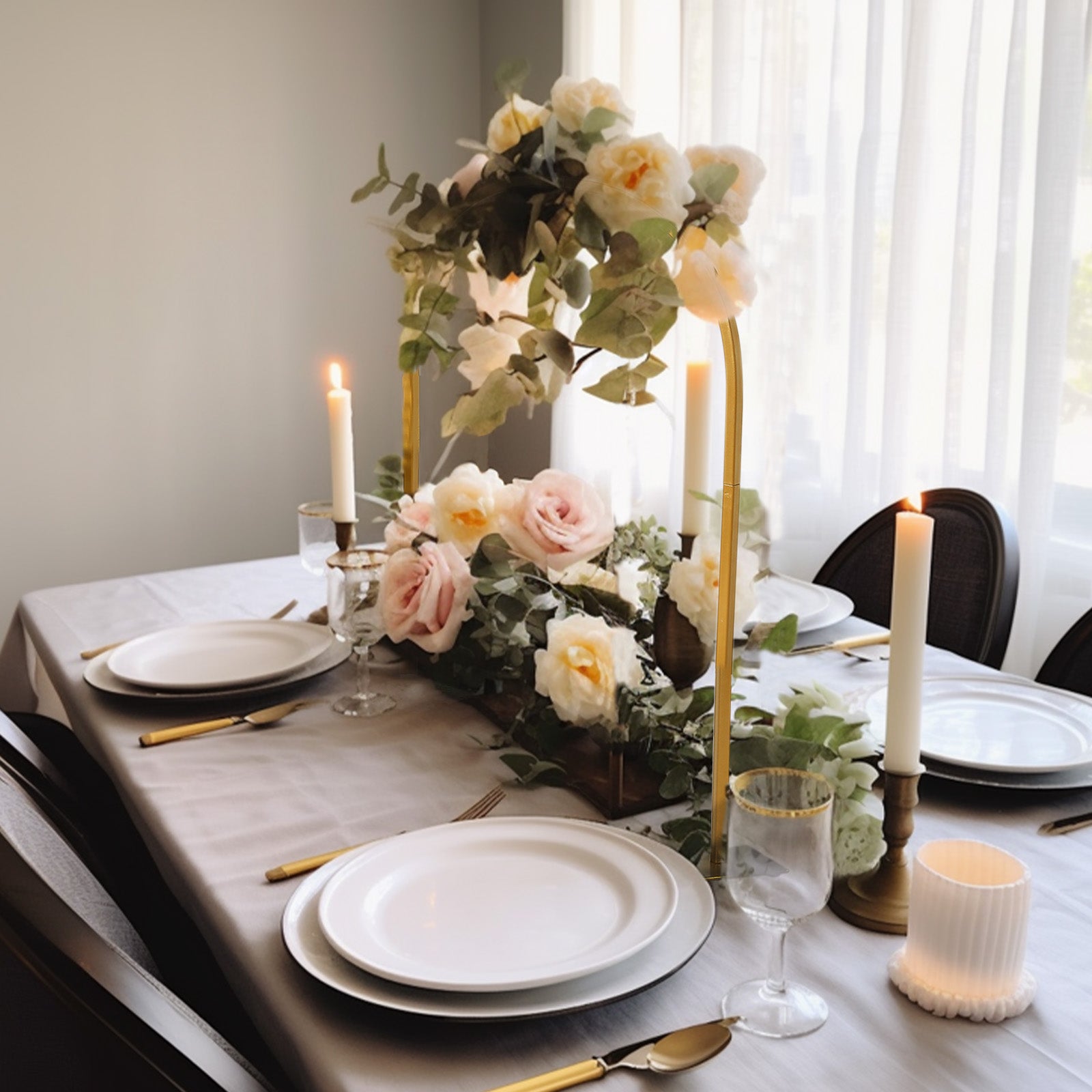 Gold metal wedding cake display stand with floral centerpiece on a dining table.