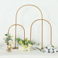 Gold metal chiara arch wedding cake display stand with floral arrangements.