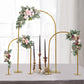 Gold metal wedding cake display stands with floral accents and rounded tops.