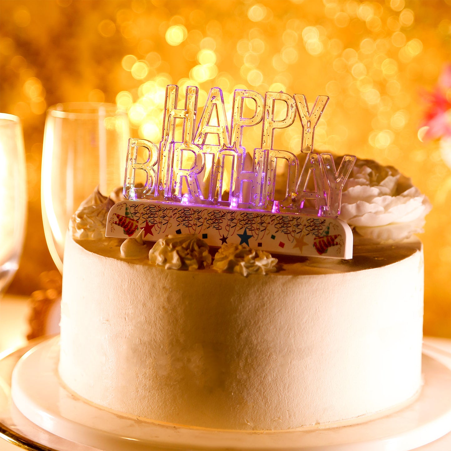 Clear multicolor flashing LED birthday cake topper on a white cake.