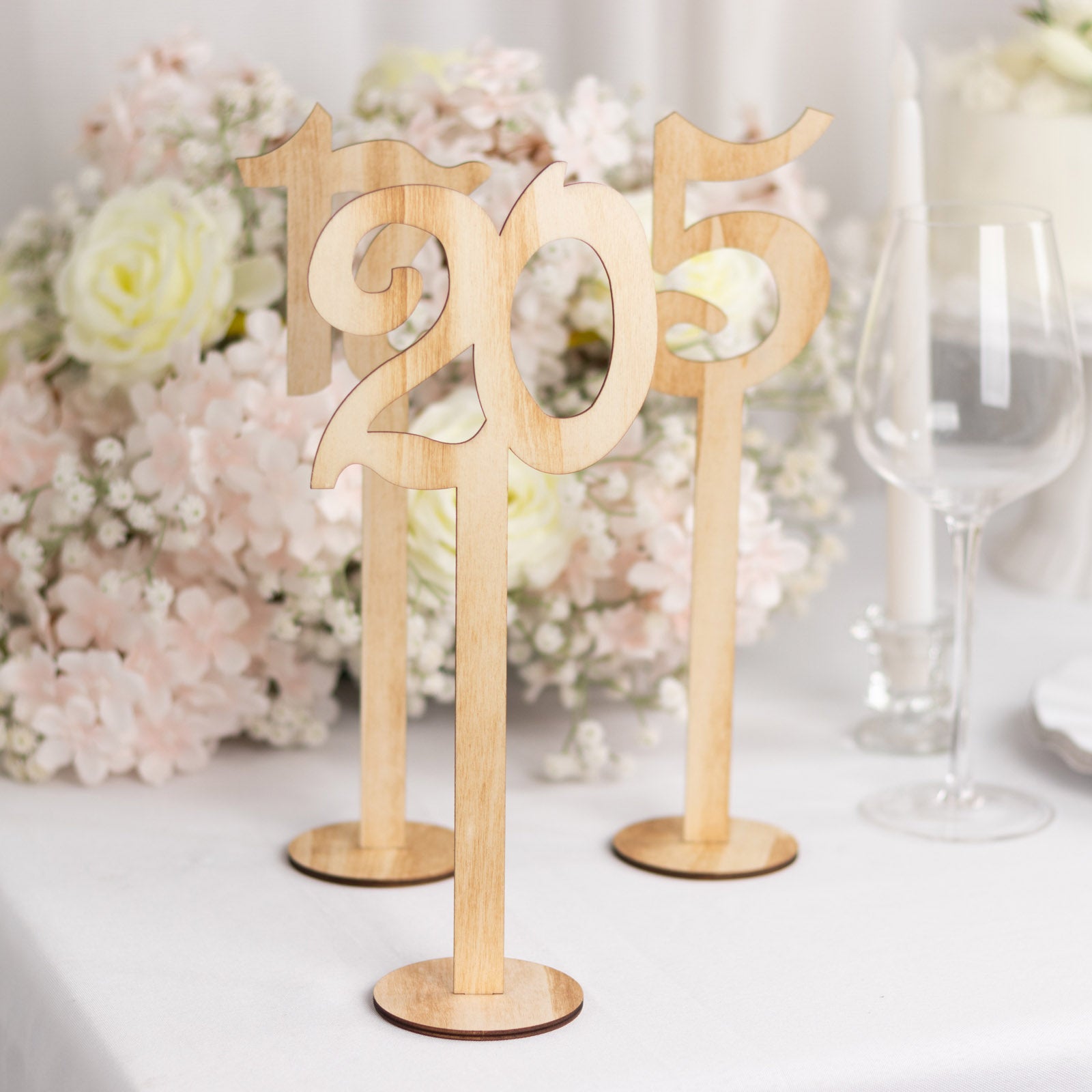 Natural wooden wedding table numbers on sticks with round base.