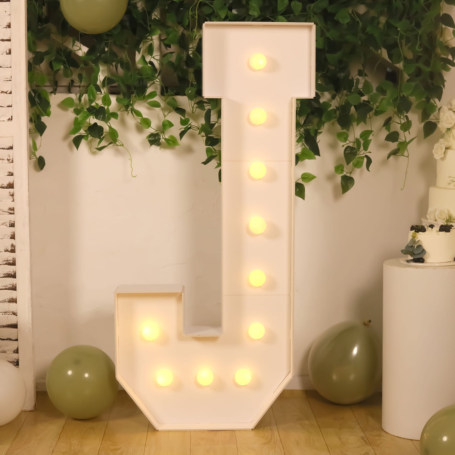 White giant LED marquee letter "J" with warm white lights.