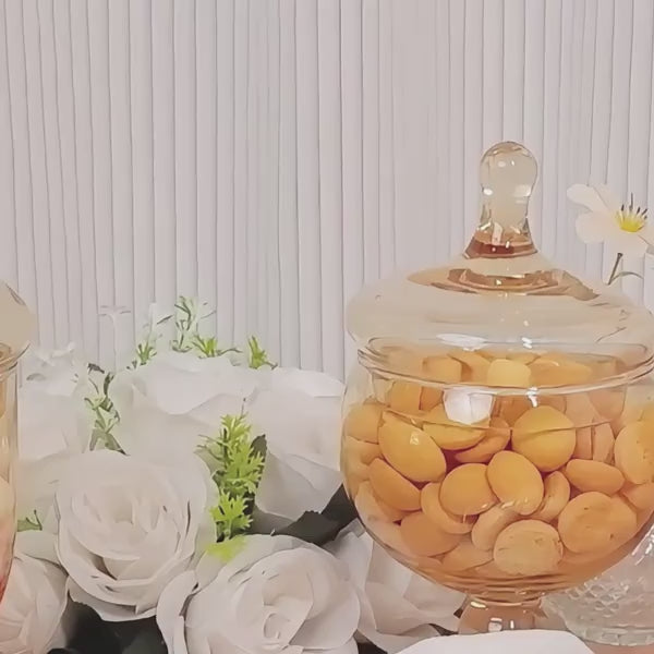 Amber gold decorative glass jars with snap-on lids and footed bases.