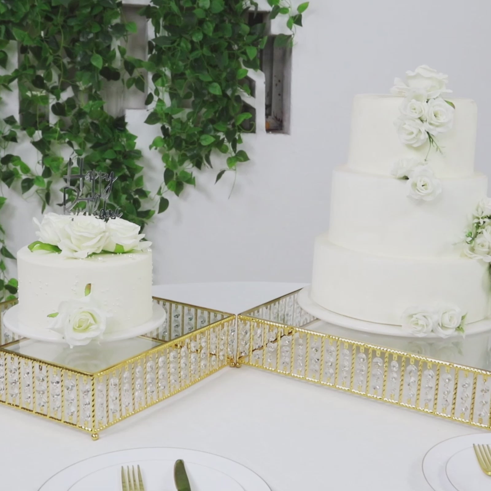 Gold cake stand with hanging crystal beads displaying white cakes.