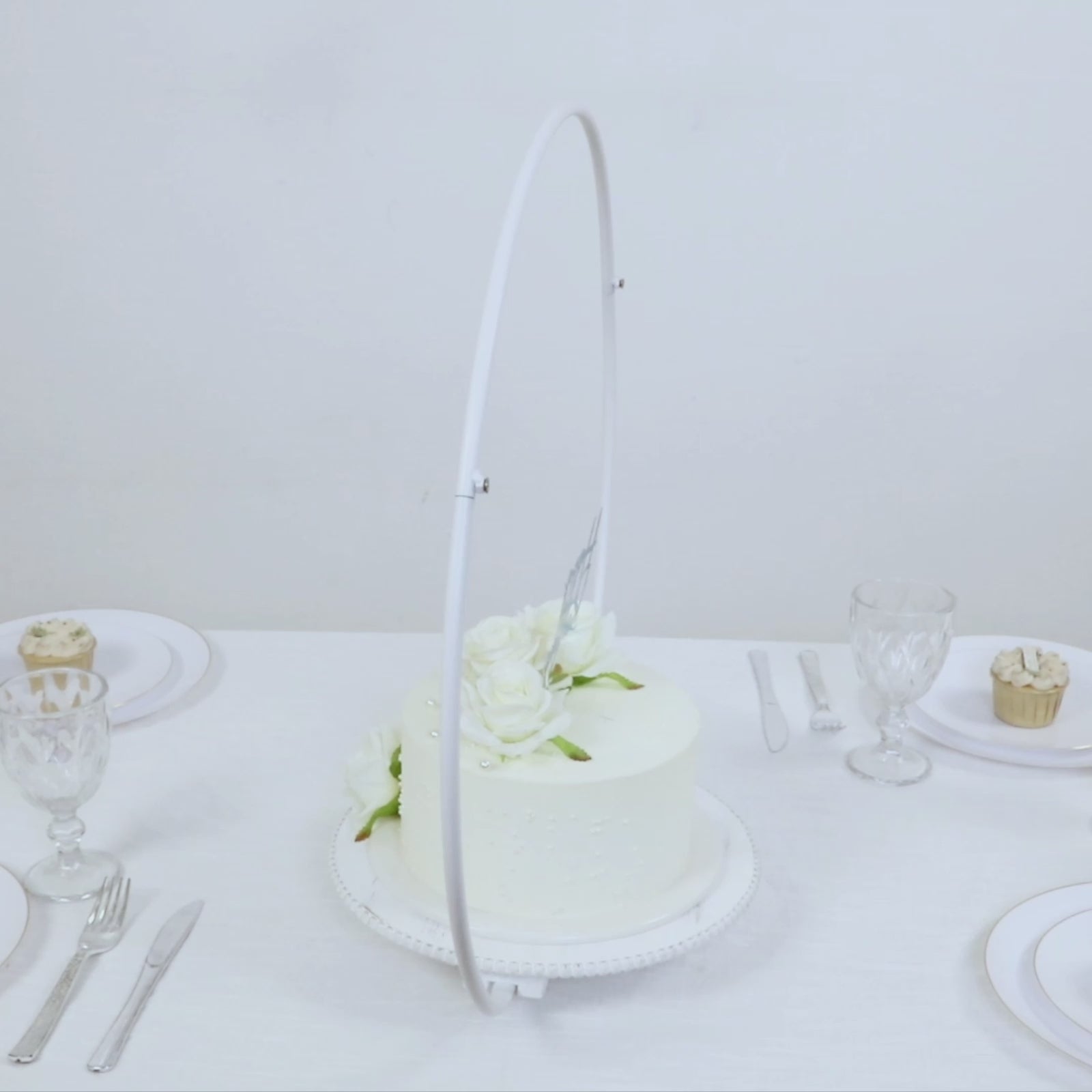 Whitewashed metal floral hoop cake stand with beaded wooden base.
