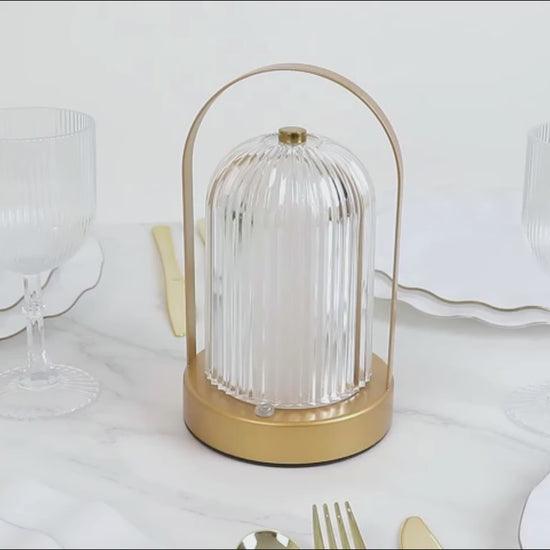 Gold LED table lamp with ribbed acrylic shade, touch control, and cordless design.