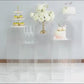 Clear acrylic pedestal stands displaying desserts and flowers.