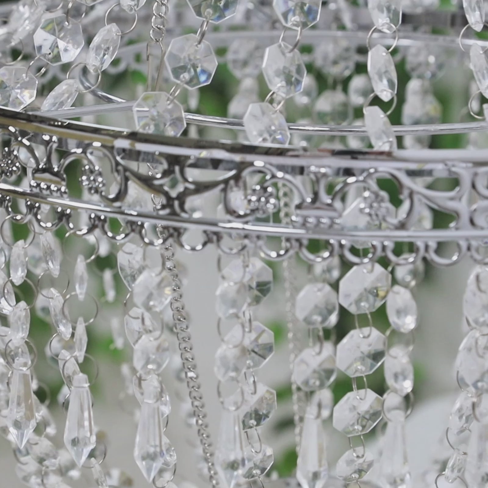 Silver beaded crystal chandelier with ornate metal frame.