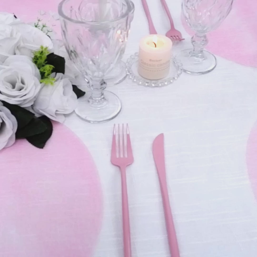 Pink disposable placemats on a dining table with glassware and flowers.