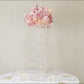 Clear acrylic chandelier flower stand with pink flowers and hanging crystals.